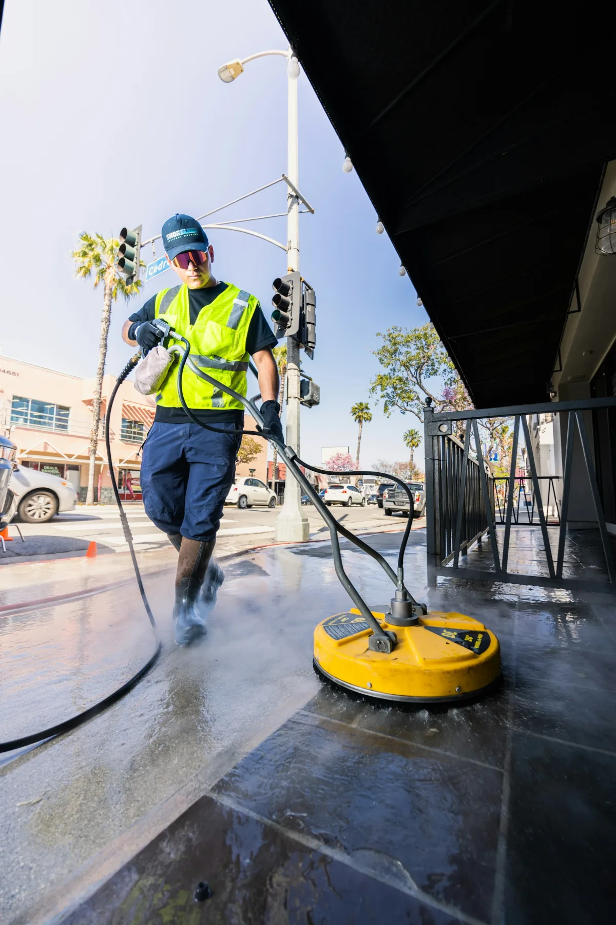 Shiny's team member pressure washing a driveway